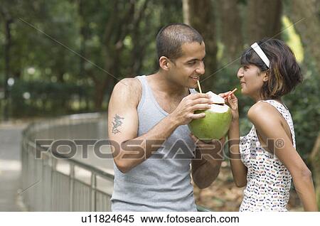 Young couple drinking coconut milk and smiling View Large Photo Image Stock Photography - Young couple drinking coconut milk and smiling. Fotosearch