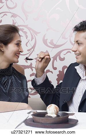 Young man feeding an ice-cream to a young woman View Large Photo Image Stock Image - Young man feeding an ice-cream to a young woman. Fotosearch