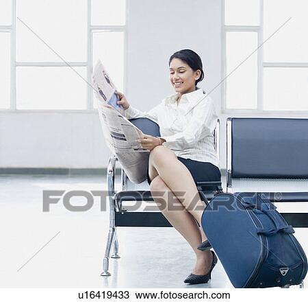 Businesswoman sitting at an airport and reading a newspaper View Large Photo Image Stock Image - Businesswoman sitting at an airport and reading a newspaper. Fotosearch