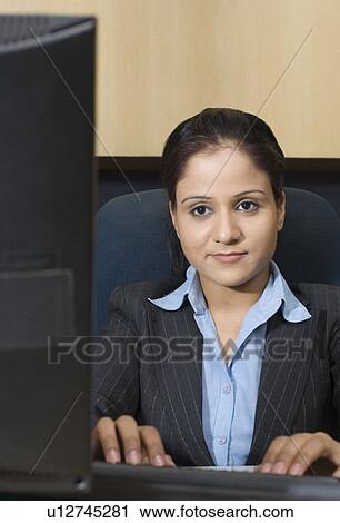 Businesswoman working on a computer in an office View Large Photo Image Stock Image - Businesswoman working on a computer in an office. Fotosearch