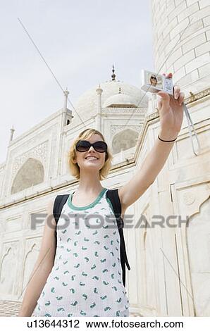 Low angle view of a young woman taking a picture of herself, Taj Mahal, Agra, Uttar Pradesh, India View Large Photo Image Stock Image - Low angle view of a young woman taking a picture of herself, Taj Mahal, Agra, Uttar Pradesh, India. Fotosearch