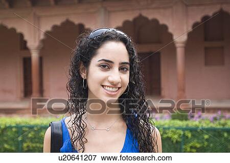 Stock Photo - Portrait of a young woman smiling, Taj Mahal, Agra, Uttar Pradesh, India. Fotosearch