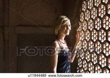 Portrait of a young woman standing near a window and smiling, Taj Mahal, Agra, Uttar Pradesh, India View Large Photo Image Stock Photo - Portrait of a young woman standing near a window and smiling, Taj Mahal, Agra, Uttar Pradesh, India. Fotosearch
