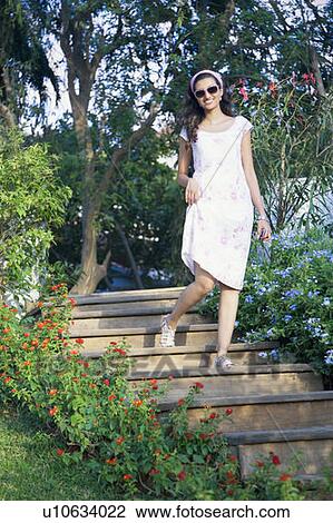 Young woman moving down on steps and smiling View Large Photo Image Stock Image - Young woman moving down on steps and smiling. Fotosearch