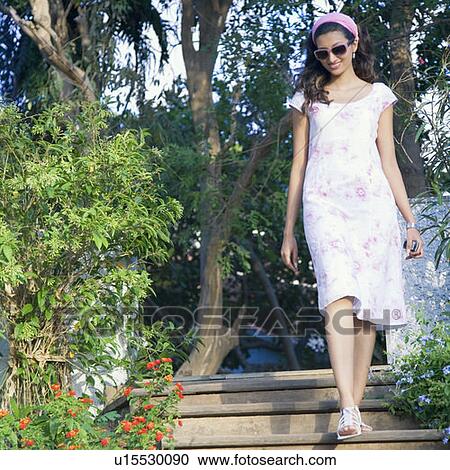Young woman moving down on steps and smiling View Large Photo Image Stock Image - Young woman moving down on steps and smiling. Fotosearch